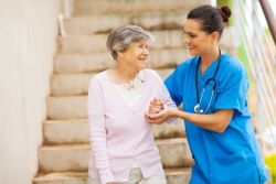 caregiver assisting an elderly woman