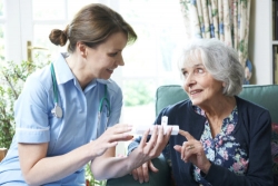 nures advising elderly woman on taking medication